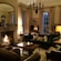 A cozy living room with a burning fireplace, 2 overstuffed chairs, a sofa and artwork